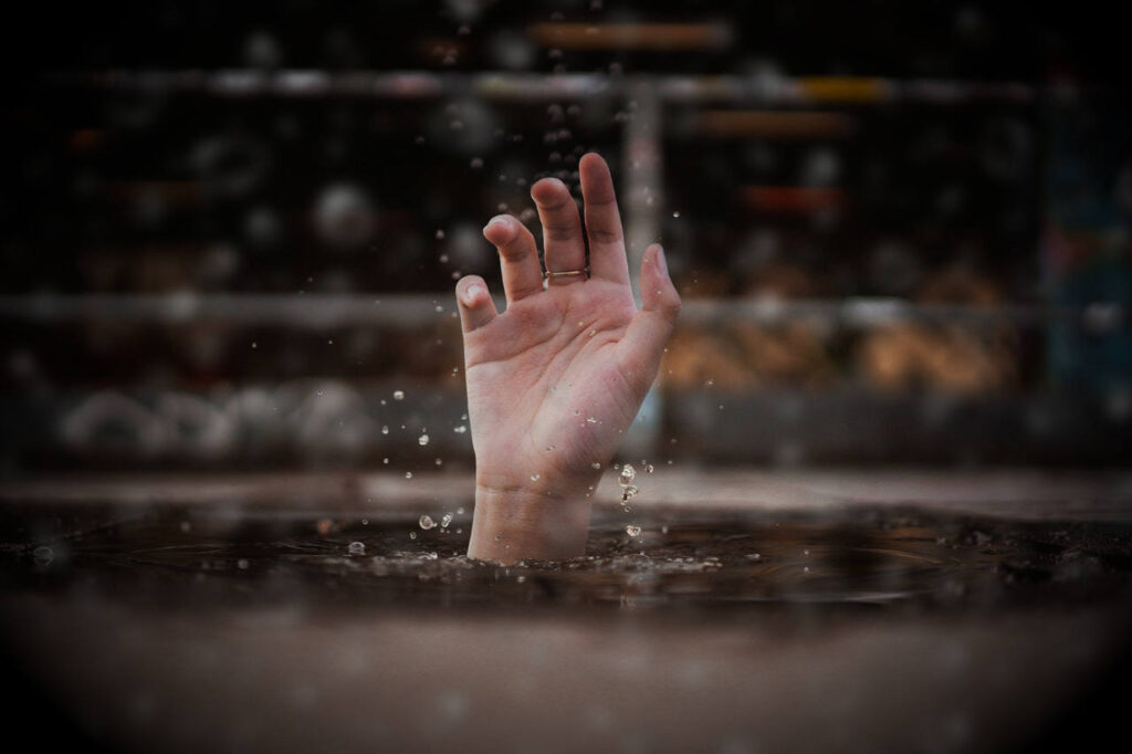 Hand reaching up out of water